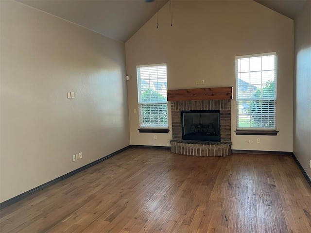 unfurnished living room featuring a fireplace, hardwood / wood-style flooring, and high vaulted ceiling