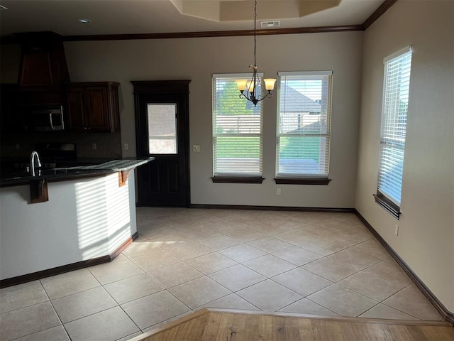 kitchen featuring pendant lighting, a chandelier, a breakfast bar area, light tile patterned floors, and ornamental molding