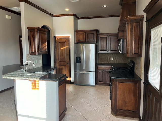 kitchen with stainless steel appliances, tasteful backsplash, crown molding, dark stone counters, and light tile patterned flooring