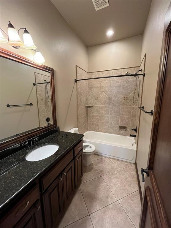 full bathroom with tile patterned floors, toilet, vanity, and tiled shower / bath