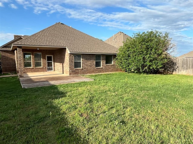 back of property with a patio area and a yard