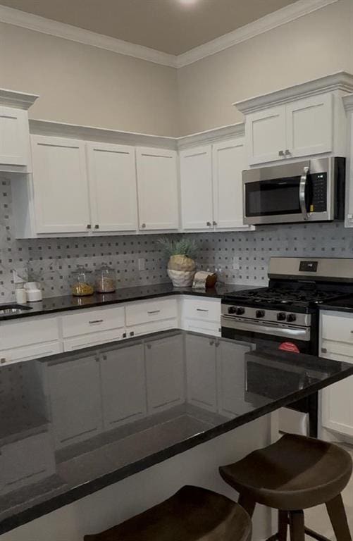 kitchen with white cabinetry, appliances with stainless steel finishes, and backsplash