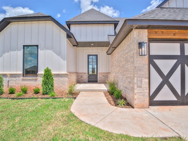 doorway to property featuring a lawn and a garage