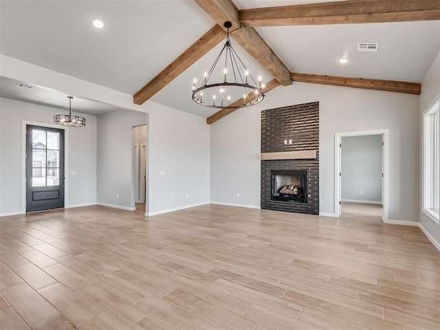 unfurnished living room with lofted ceiling with beams, an inviting chandelier, and a brick fireplace