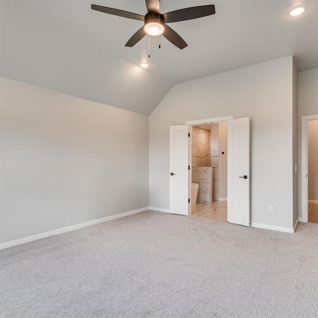 unfurnished bedroom featuring ensuite bath, ceiling fan, light carpet, and lofted ceiling