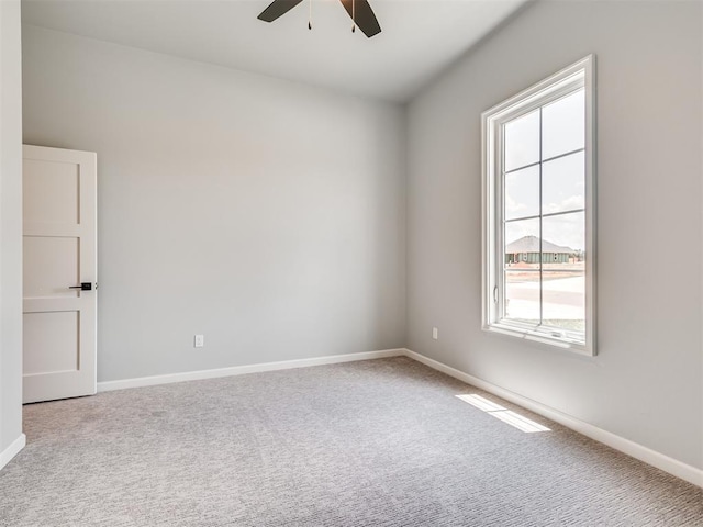 carpeted spare room with ceiling fan