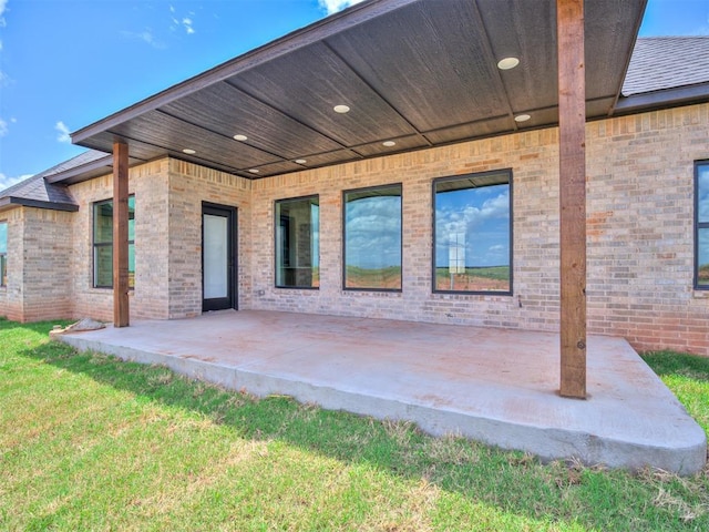 back of house with a lawn and a patio