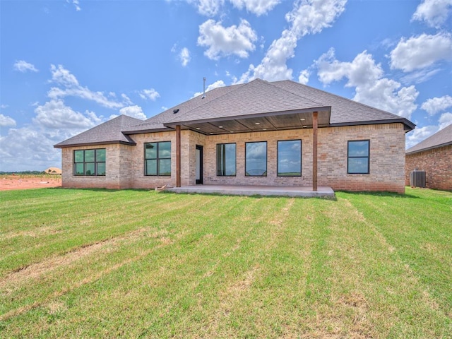 rear view of house featuring a lawn, central air condition unit, and a patio