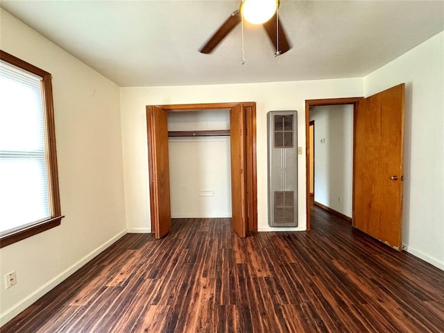 unfurnished bedroom with ceiling fan, a closet, and dark hardwood / wood-style floors