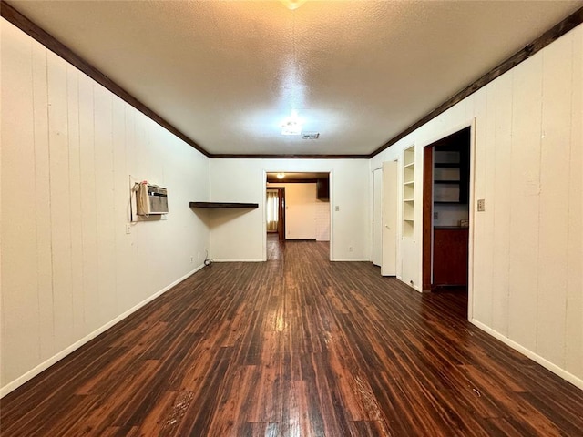 unfurnished living room featuring an AC wall unit, wooden walls, dark hardwood / wood-style flooring, and a textured ceiling