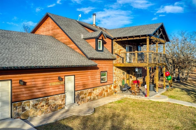 rear view of house featuring a yard, a patio, and a balcony