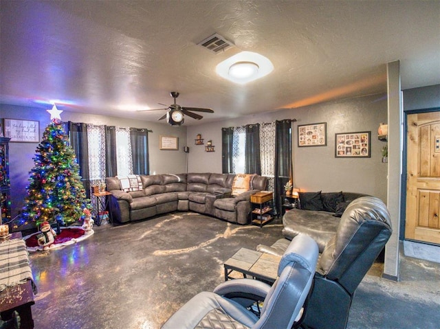 living room with ceiling fan and a textured ceiling