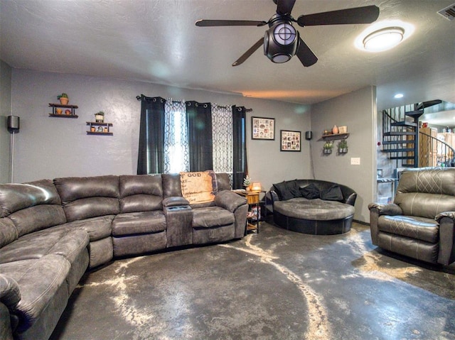 living room with ceiling fan, concrete flooring, and a textured ceiling