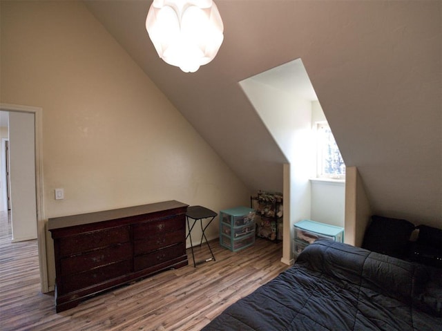 bedroom with light hardwood / wood-style flooring and lofted ceiling