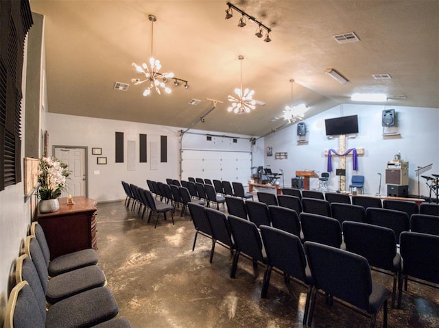 cinema room featuring a chandelier and lofted ceiling