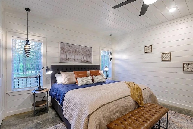 bedroom with ceiling fan and wooden walls