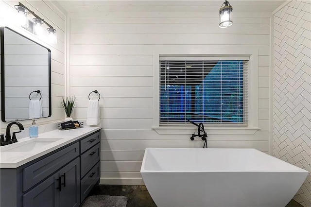 bathroom with vanity, a tub to relax in, and wooden walls