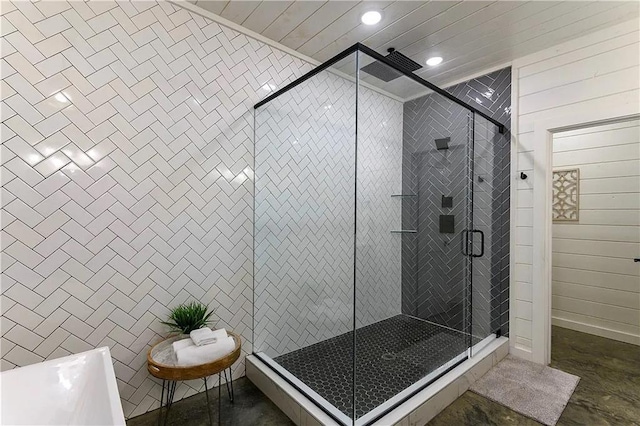 bathroom with wooden walls, concrete flooring, and plus walk in shower