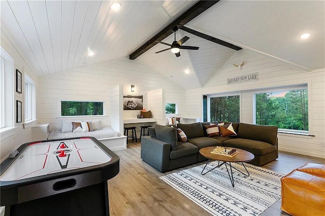 living room featuring lofted ceiling with beams, wooden walls, ceiling fan, and light hardwood / wood-style floors