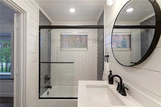 bathroom featuring bath / shower combo with glass door, vanity, and a healthy amount of sunlight