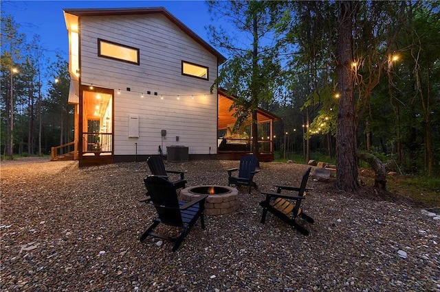 rear view of house featuring a fire pit and central AC unit