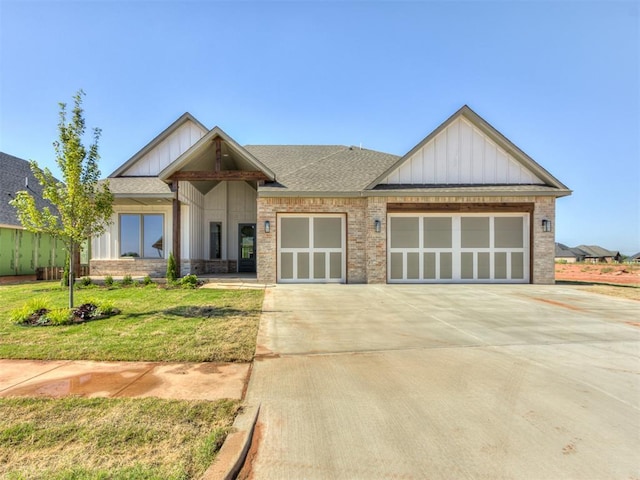 craftsman house with a garage and a front lawn