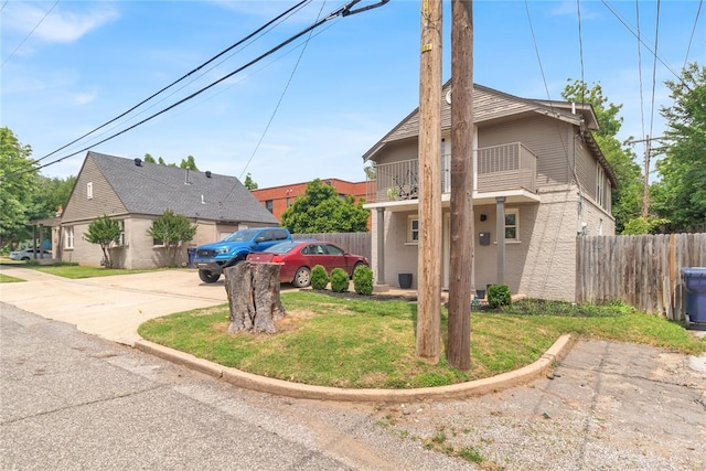 view of front of home featuring a balcony and a front lawn