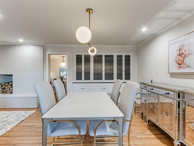 dining room with light hardwood / wood-style floors and ornamental molding