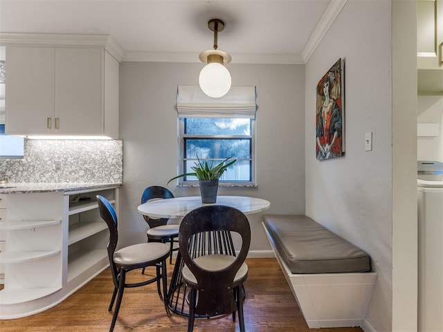 dining space with crown molding, dark wood-type flooring, and washer / clothes dryer