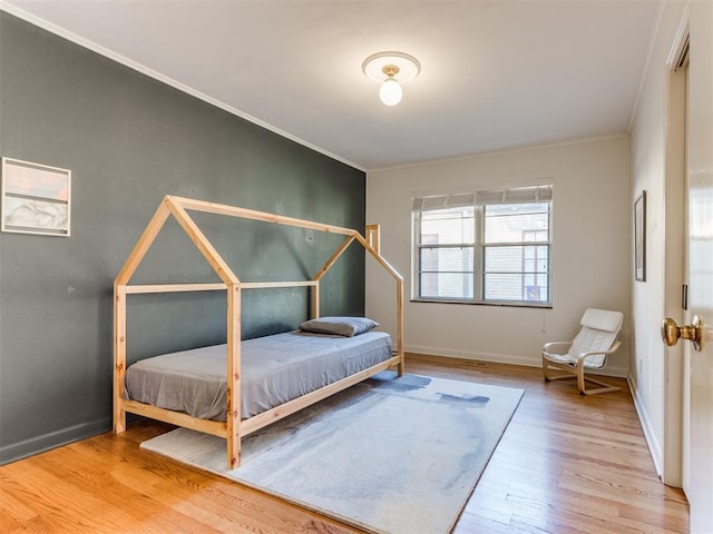 bedroom featuring hardwood / wood-style flooring and ornamental molding