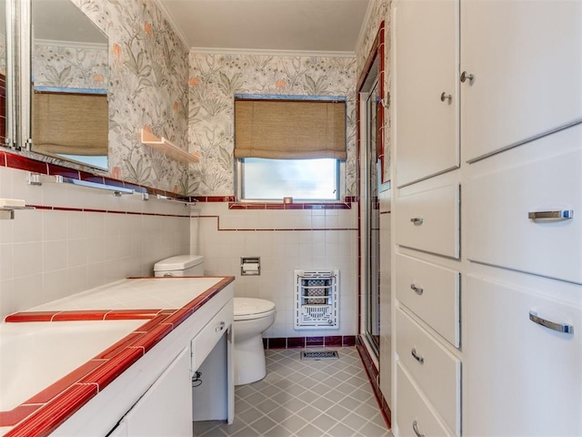 bathroom with vanity, heating unit, tile walls, tile patterned flooring, and toilet