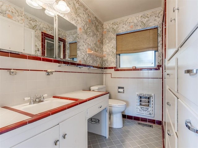 bathroom featuring vanity, heating unit, toilet, and tile walls