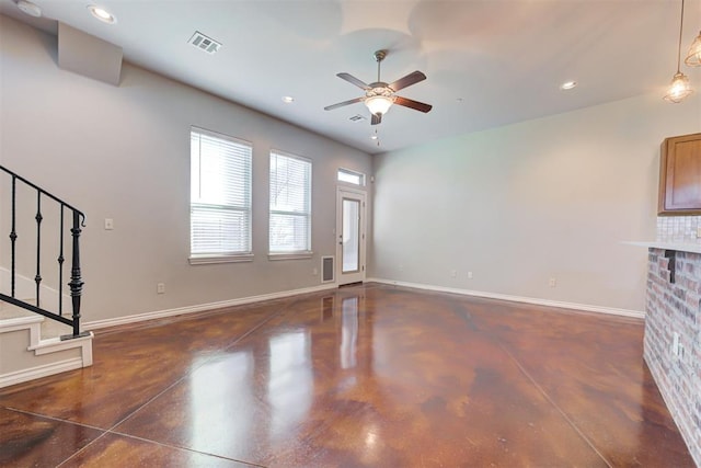 unfurnished living room featuring a brick fireplace and ceiling fan