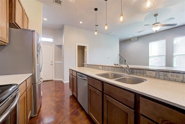 kitchen with pendant lighting, stainless steel appliances, ceiling fan, and sink