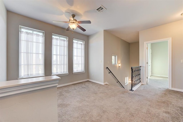 carpeted spare room with ceiling fan