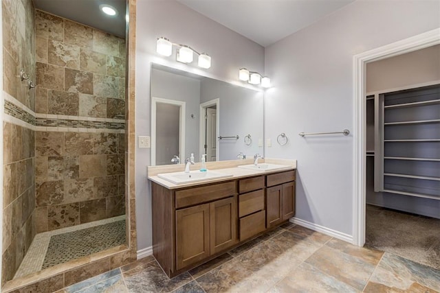 bathroom featuring a tile shower and vanity