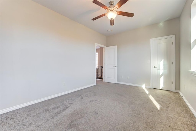 carpeted spare room featuring ceiling fan