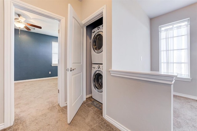 laundry room with stacked washer / dryer, light carpet, and ceiling fan