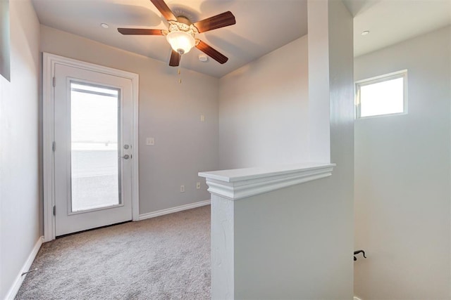 entryway with ceiling fan and light carpet