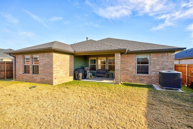 rear view of house with central AC, a yard, and a patio