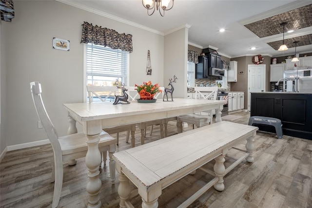 dining room featuring crown molding, sink, and light wood-type flooring