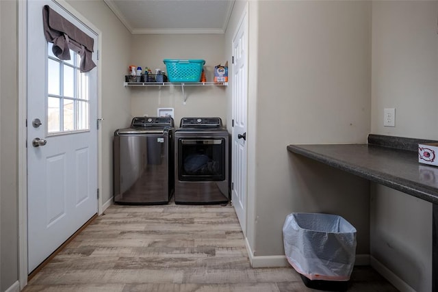 laundry room featuring crown molding, washing machine and clothes dryer, and light wood-type flooring