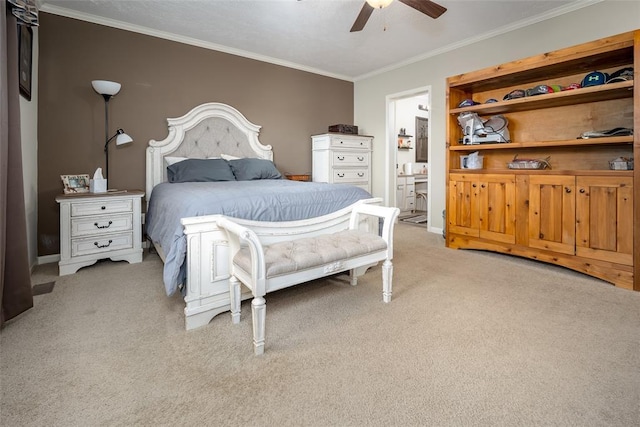 carpeted bedroom with ceiling fan, ensuite bath, and ornamental molding