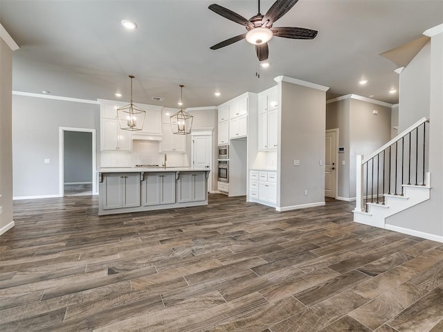 kitchen featuring white cabinetry, a ceiling fan, tasteful backsplash, and ornamental molding