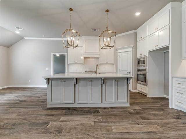 kitchen with light countertops, white cabinets, visible vents, and stainless steel appliances