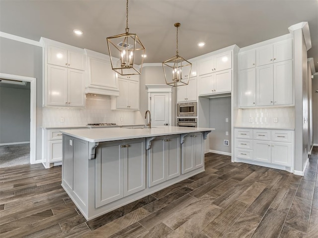 kitchen with tasteful backsplash, appliances with stainless steel finishes, white cabinets, and an inviting chandelier