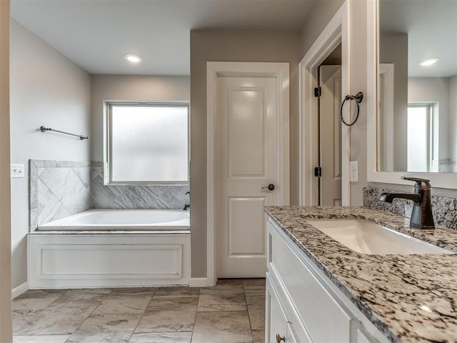 full bath featuring vanity, a bath, and recessed lighting