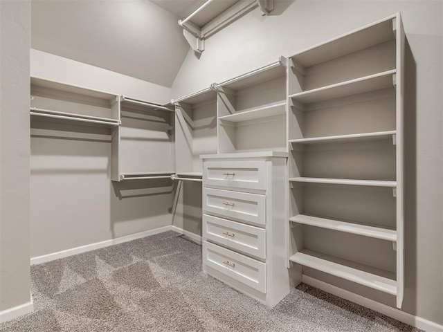 spacious closet featuring lofted ceiling and light colored carpet