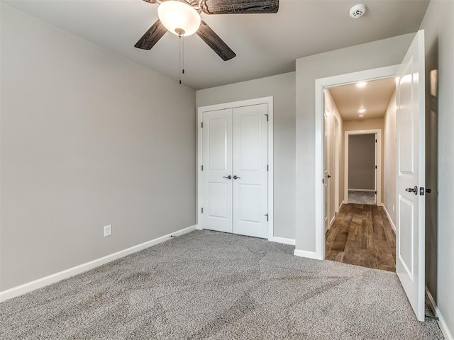 unfurnished bedroom with a closet, baseboards, a ceiling fan, and carpet flooring