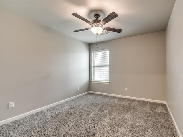 spare room with visible vents, a ceiling fan, baseboards, and carpet floors